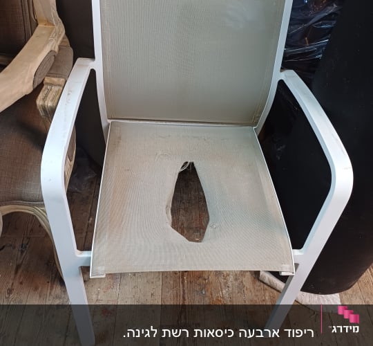 כיסא עם ריפוד קרוע במושב על רצפת עץ